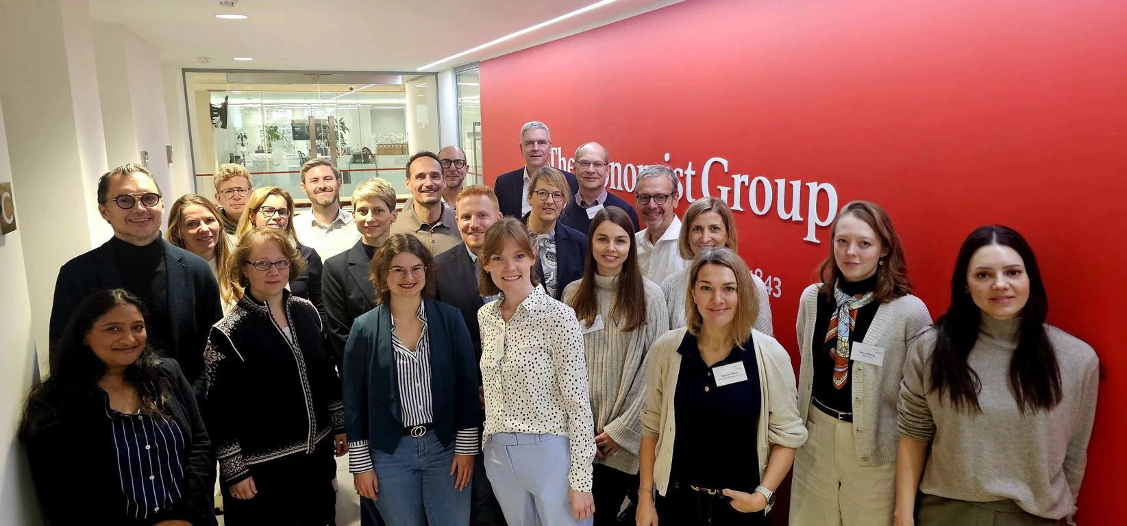 Teilnehmende der Subscription Tour vor der The Economist Group Wand in London